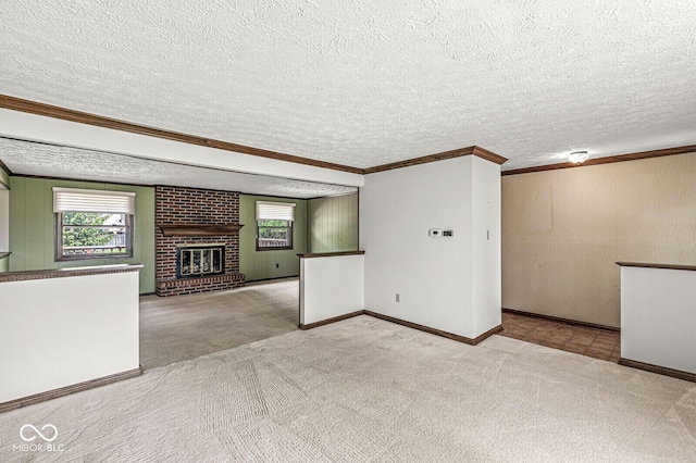 unfurnished living room with plenty of natural light, carpet flooring, crown molding, baseboards, and a textured ceiling