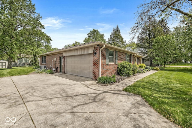 view of side of property featuring brick siding, an attached garage, concrete driveway, a yard, and a storage shed