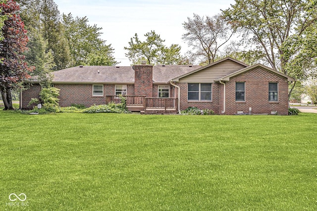 rear view of property with a deck, brick siding, and a lawn