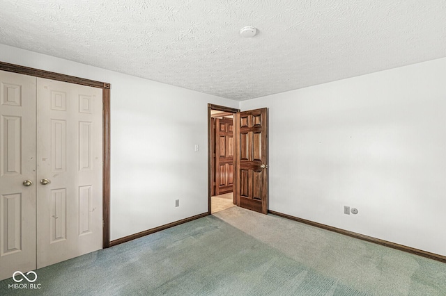 unfurnished bedroom with carpet flooring, baseboards, a textured ceiling, and a closet