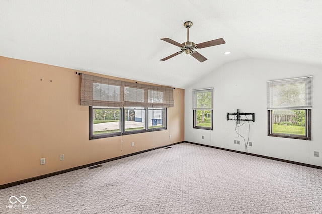 spare room featuring carpet, a ceiling fan, lofted ceiling, and baseboards