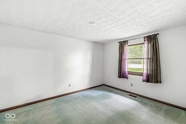 empty room featuring carpet flooring, a textured ceiling, and baseboards