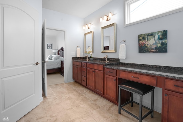 full bathroom with a sink, ensuite bath, and double vanity