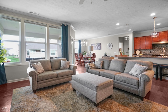 living room with crown molding, dark wood-style flooring, visible vents, and recessed lighting