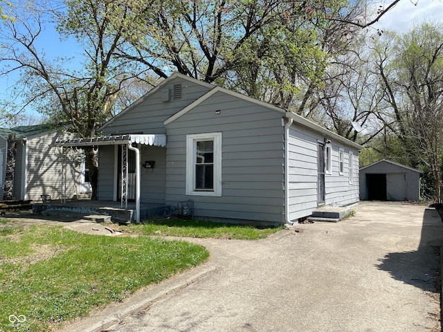 3541 Orchard Ave, Indianapolis, IN 46218 - bungalow with a porch, a garage, an outbuilding, and driveway