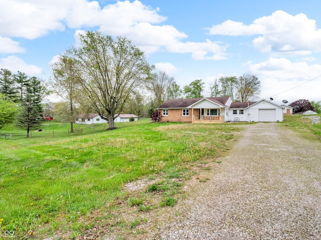 ranch-style home with a front lawn, gravel driveway, an attached garage, and covered porch