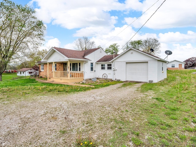 view of front facade with a porch, a front yard, and dirt driveway