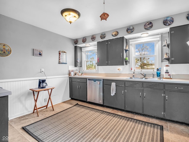 kitchen with a sink, dishwasher, wainscoting, and open shelves