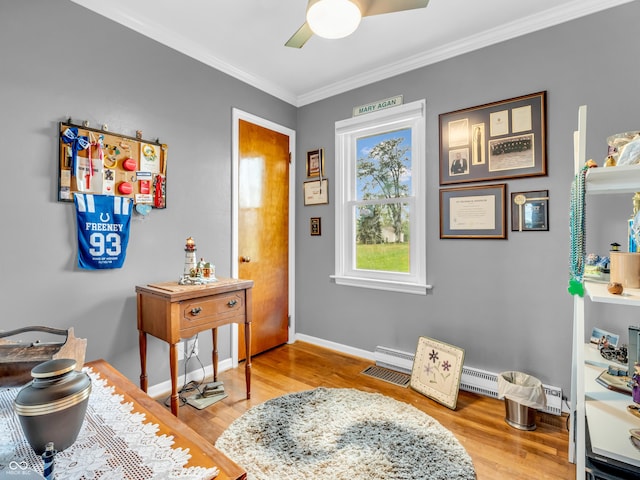 entryway with wood finished floors, a baseboard heating unit, ornamental molding, baseboards, and a ceiling fan