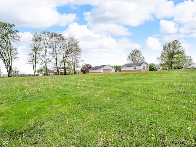 view of yard featuring a garage and a rural view