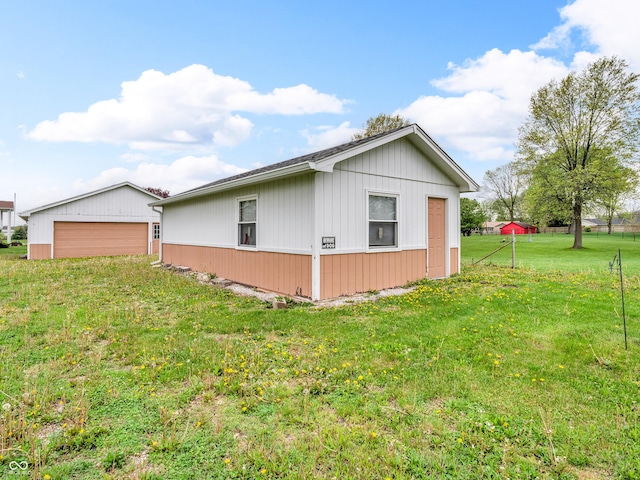 view of side of home with a lawn, an outbuilding, and a garage