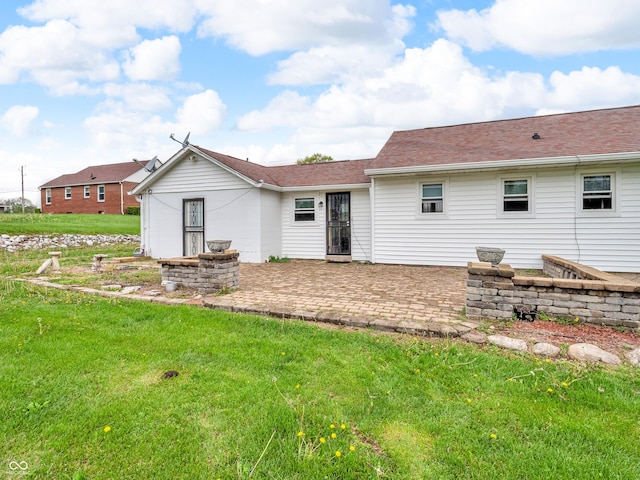 rear view of property with a yard and a patio area