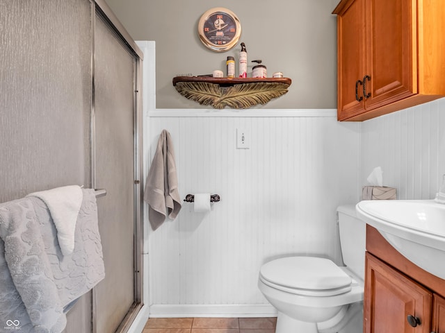 bathroom featuring a wainscoted wall, tile patterned flooring, and a shower stall