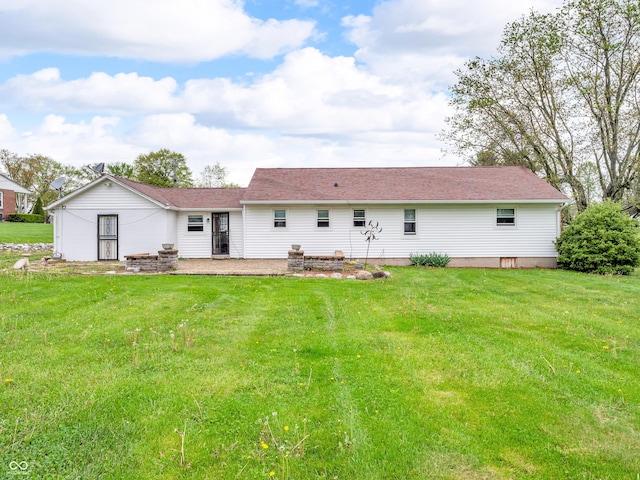 rear view of property featuring a yard, a patio area, and roof with shingles