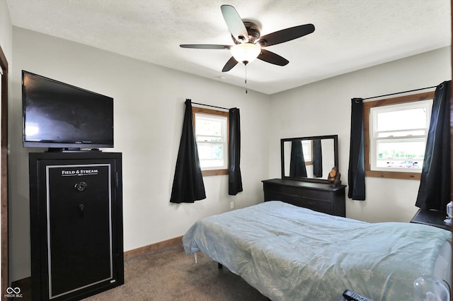 carpeted bedroom featuring baseboards, a ceiling fan, and a textured ceiling
