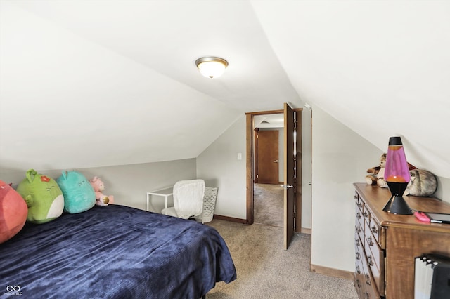 bedroom with baseboards, lofted ceiling, and light carpet