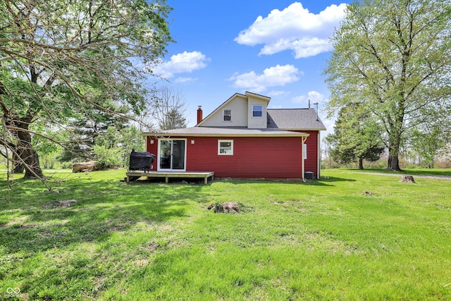 rear view of house featuring a yard and a chimney