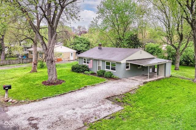 ranch-style house featuring a carport, a chimney, a front yard, fence, and brick siding