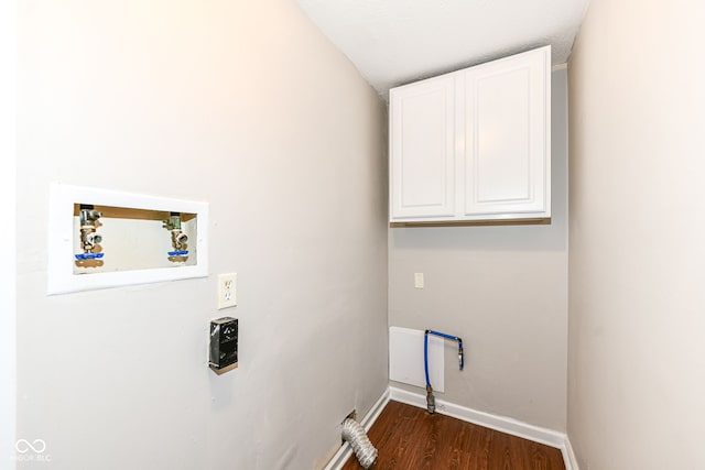laundry area with dark wood-type flooring, washer hookup, cabinet space, and baseboards