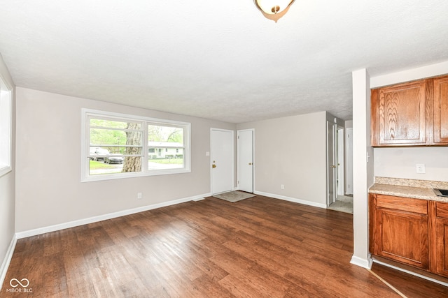 unfurnished living room featuring dark wood-style floors and baseboards