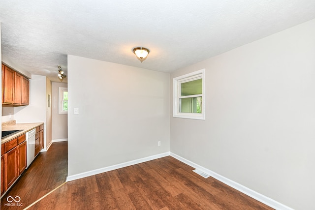spare room with visible vents, baseboards, and dark wood-type flooring