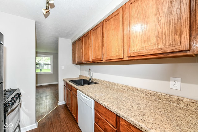kitchen featuring brown cabinets, a sink, dark wood-style floors, gas range, and dishwasher