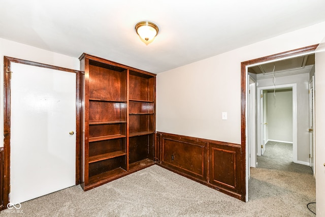 unfurnished room with attic access and carpet