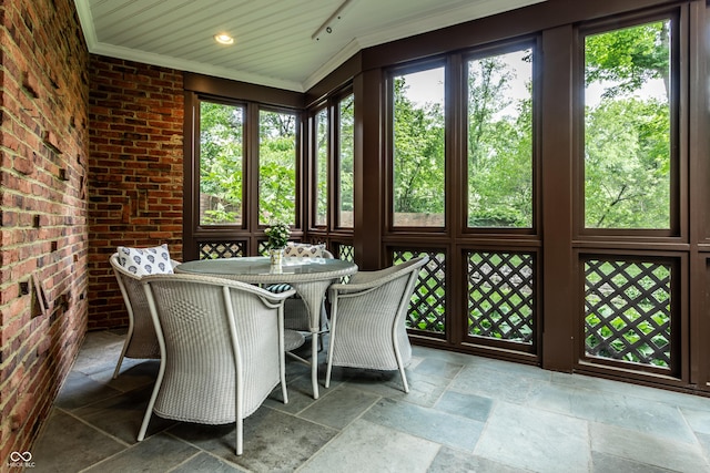 sunroom / solarium featuring outdoor dining area and a wealth of natural light