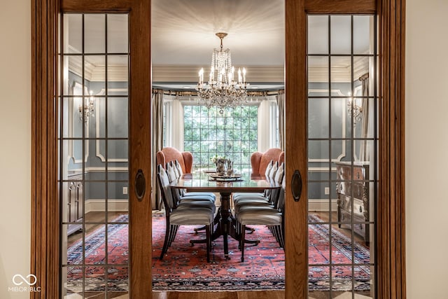 dining space with crown molding, baseboards, and a chandelier