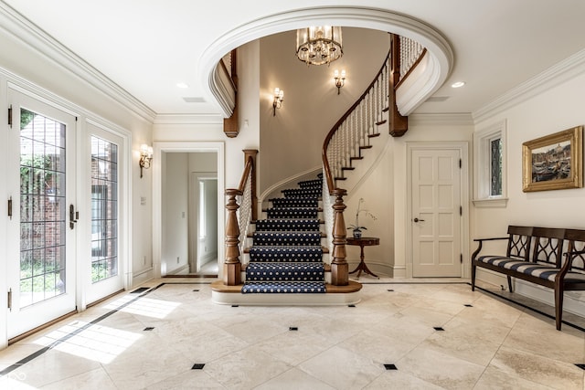 entryway with crown molding, baseboards, stairs, and a chandelier
