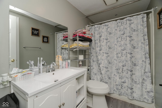 bathroom with vanity, wood finished floors, toilet, and shower / bath combo with shower curtain