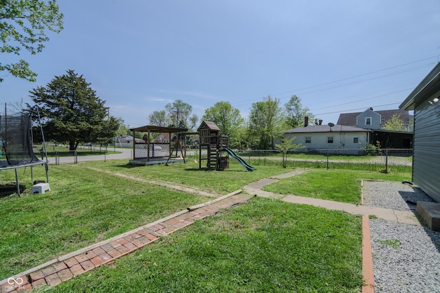 view of yard with fence, a trampoline, and playground community