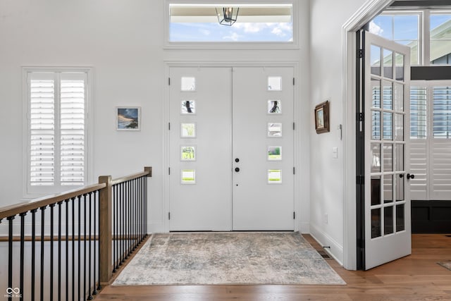 foyer entrance with plenty of natural light, baseboards, and wood finished floors