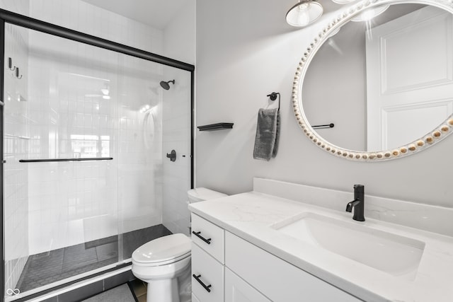 bathroom with vanity, toilet, and a shower stall
