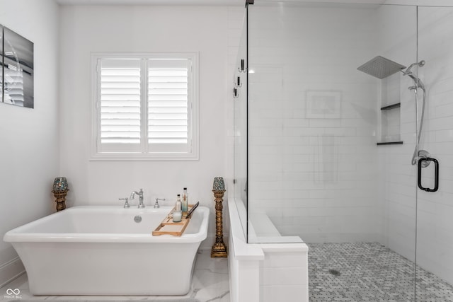 bathroom featuring a freestanding bath and a shower stall