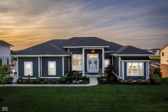 view of front of home featuring board and batten siding, roof with shingles, and a front lawn