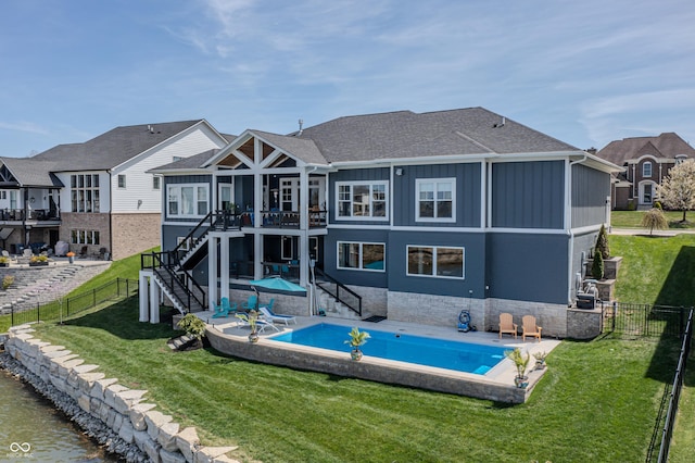 back of property featuring board and batten siding, a lawn, stairs, and a fenced backyard