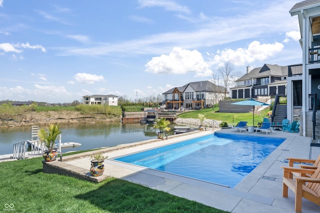 pool with a lawn, a water view, and a patio area