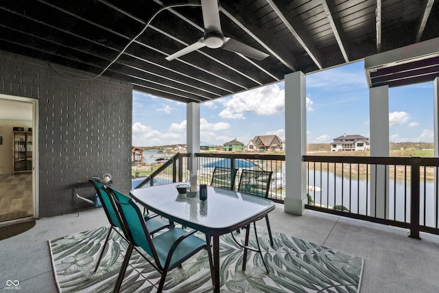 balcony featuring a ceiling fan, a residential view, a water view, and outdoor dining space