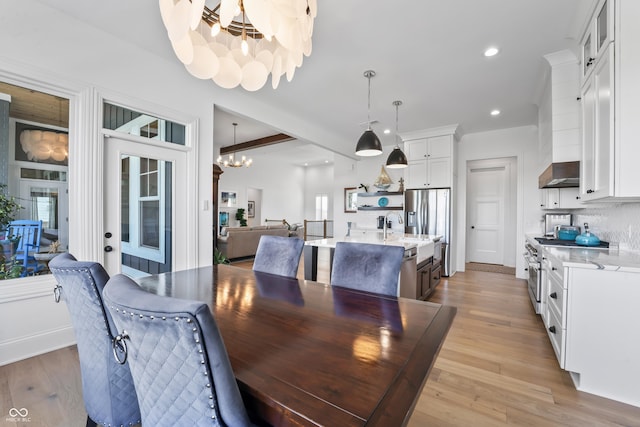 dining area featuring light wood-style floors, recessed lighting, and a notable chandelier