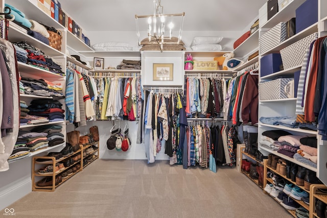 spacious closet with an inviting chandelier and carpet