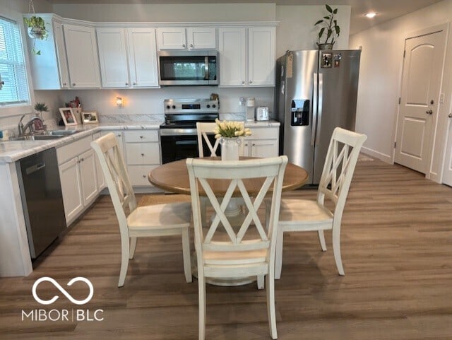 1511 Coen Ct, Columbus, IN 47201 - kitchen featuring white cabinets, stainless steel appliances, and light wood finished floors