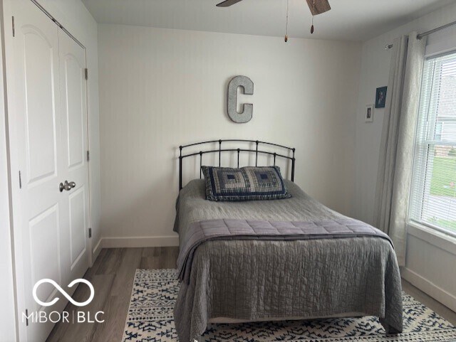 1511 Coen Ct, Columbus, IN 47201 - bedroom with baseboards, wood finished floors, a ceiling fan, and multiple windows