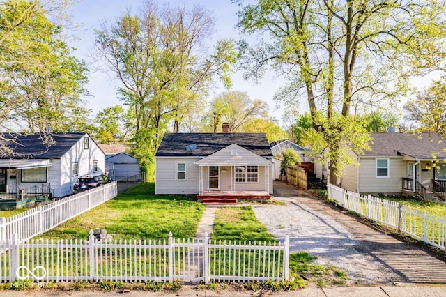 3322 W 22nd St, Indianapolis, IN 46222 - bungalow with a chimney, a fenced front yard, covered porch, driveway, and a front lawn