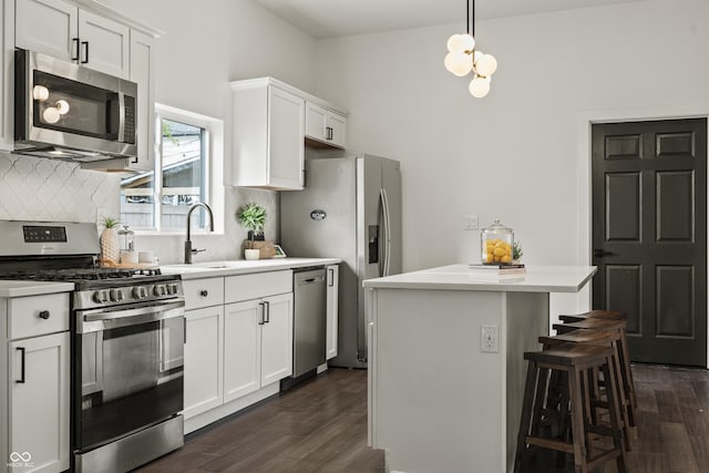 629 N Keystone Ave, Indianapolis, IN 46201 - kitchen featuring stainless steel appliances, a sink, tasteful backsplash, dark wood-style flooring, and a center island