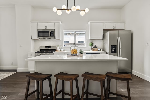 629 N Keystone Ave, Indianapolis, IN 46201 - kitchen featuring appliances with stainless steel finishes, a kitchen breakfast bar, white cabinets, backsplash, and light countertops