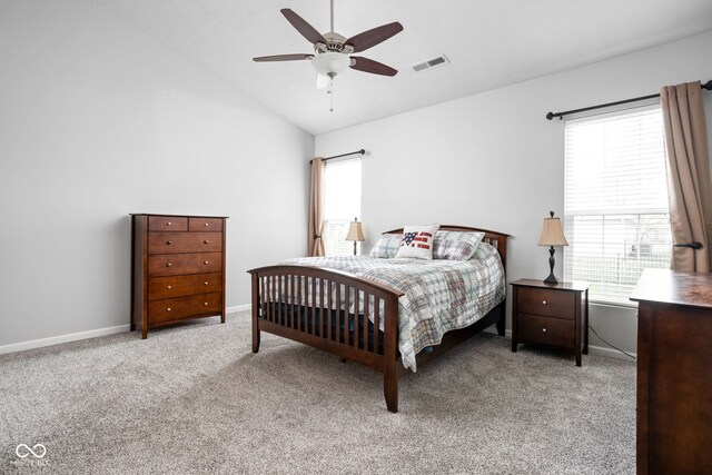 bedroom featuring baseboards, multiple windows, lofted ceiling, and light carpet