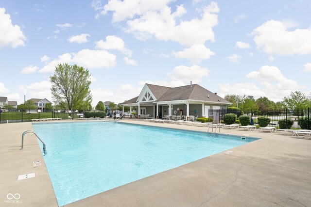 community pool with fence and a patio