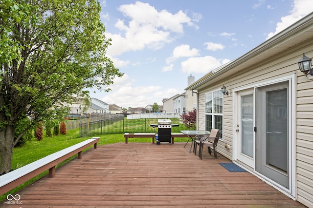 wooden deck featuring a fenced backyard, a lawn, area for grilling, and a residential view
