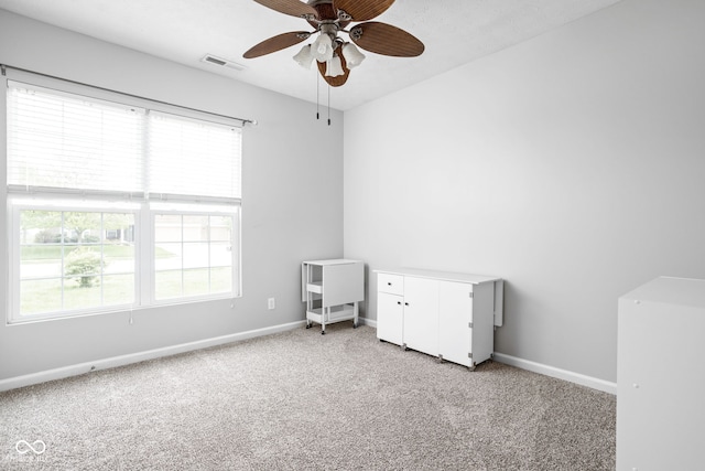unfurnished bedroom with visible vents, baseboards, multiple windows, and light colored carpet